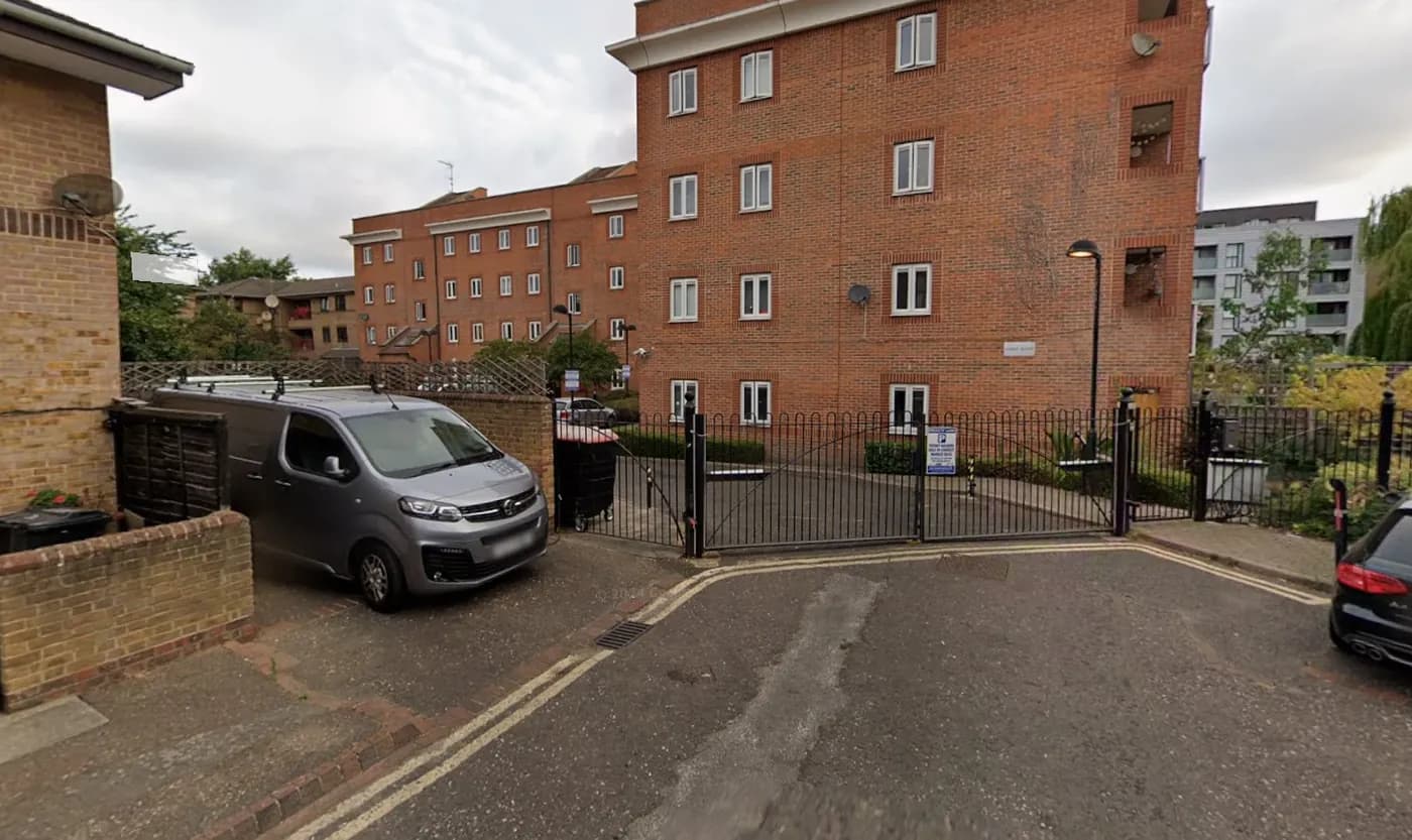 Street View of the gated entrance to a block of flats by the canal